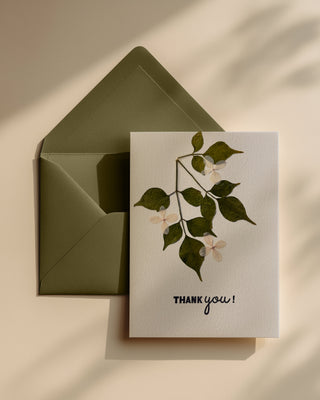 Hand made greeting card with floral design made using real pressed flowers and 'Thank you!' text on a beige background